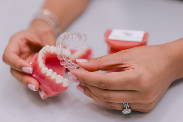 Close-up of a smiling lips with ceramic braces, showcasing straight white teeth and a natural pink lip color